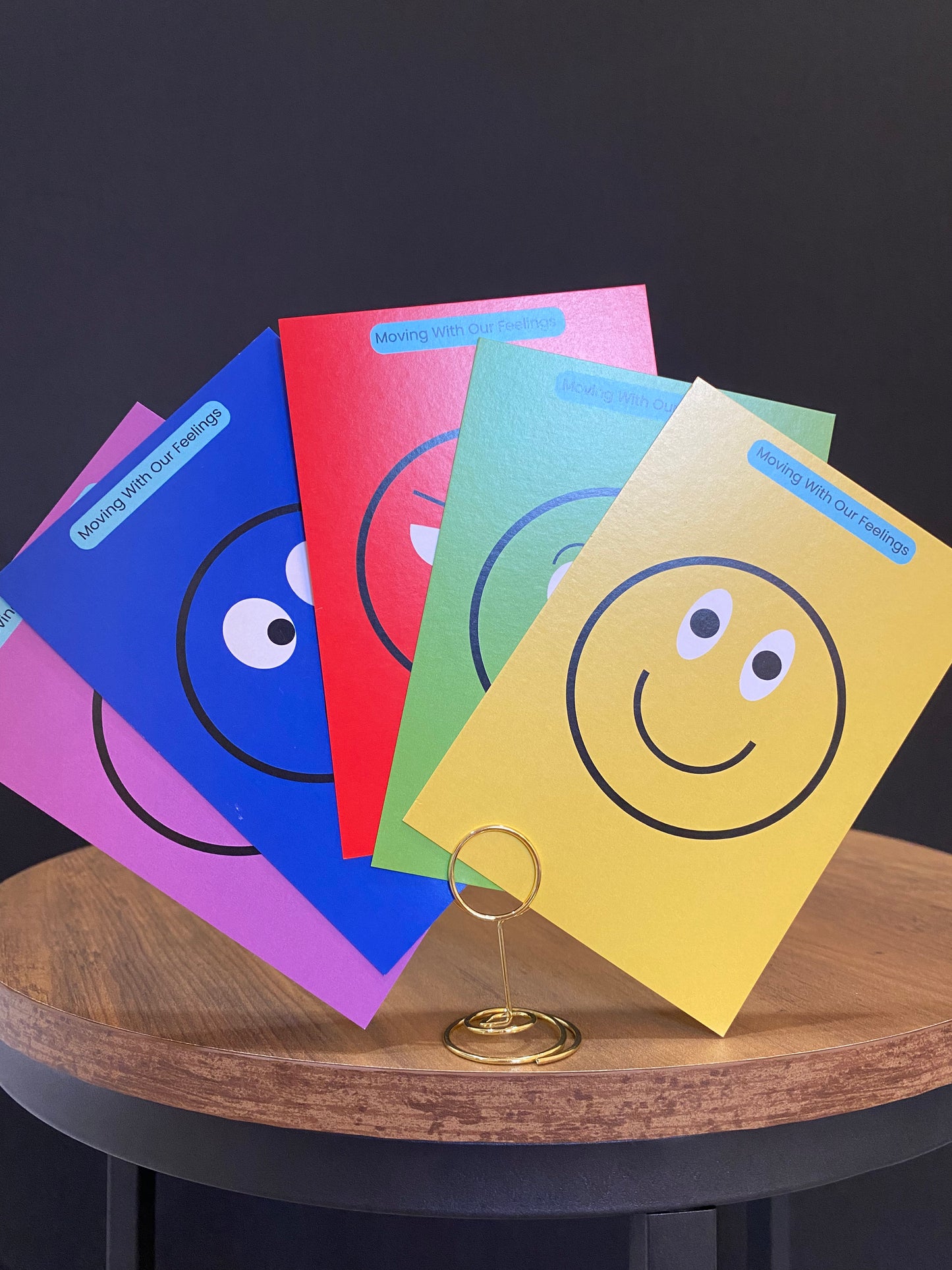 Colorful children's books with smiley face designs on a wooden table.