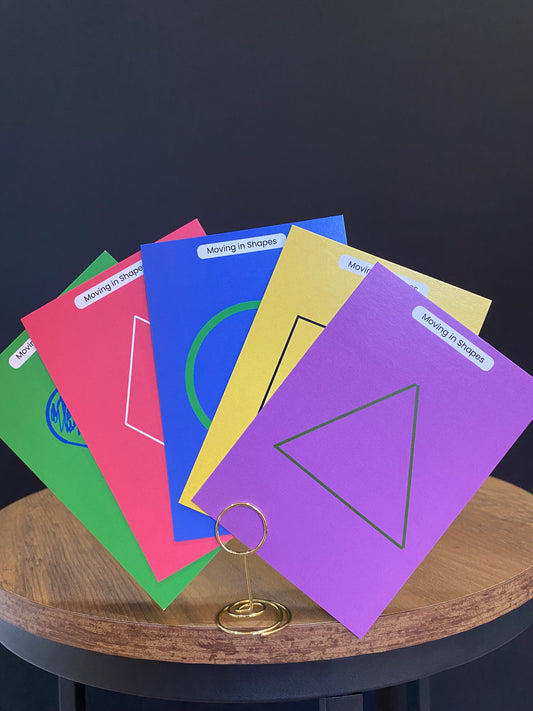 Colorful educational worksheets with geometric shapes on a wooden table.